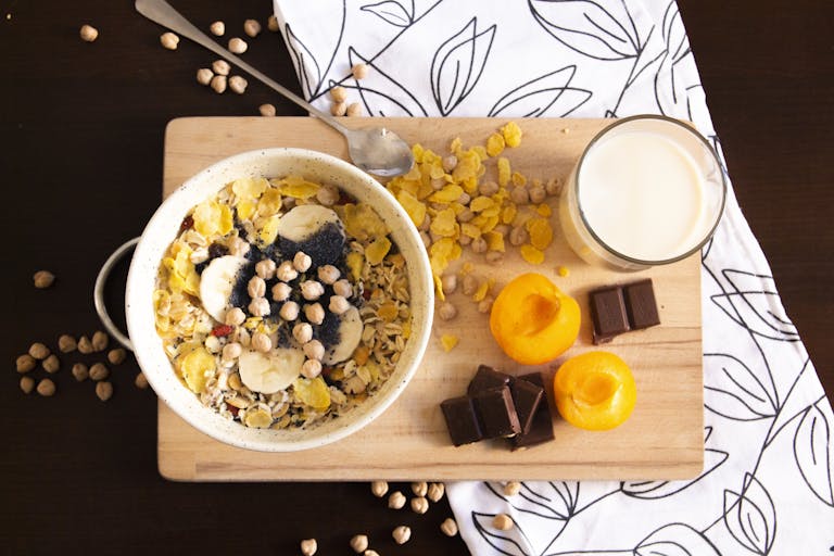 Delicious and healthy breakfast bowl with apricots, cereals, chocolate, and soy milk.