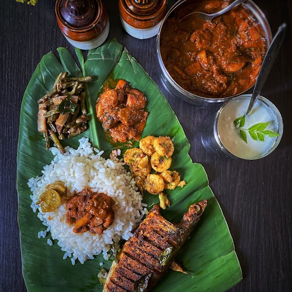 Delicious South Indian meal served on banana leaf with rice and fish curry.