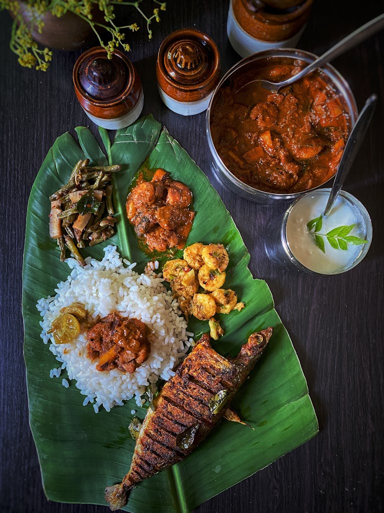 Delicious South Indian meal served on banana leaf with rice and fish curry.