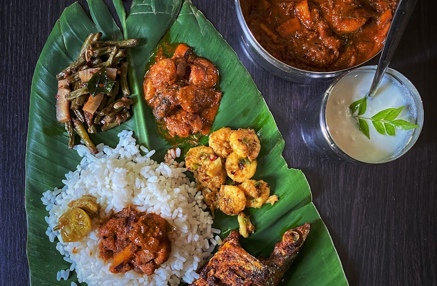 Delicious South Indian meal served on banana leaf with rice and fish curry.