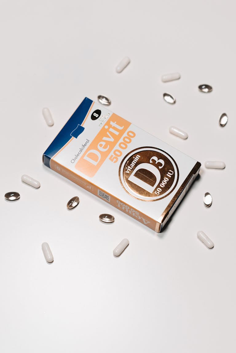 Vitamin D3 50000 IU supplement box surrounded by capsules on a white background.